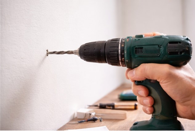 Drilling holes for wall anchors when installing a shelf
