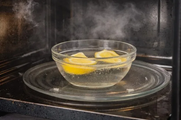 Glass bowl of lemon water steaming on the microwave turntable behind the closed door